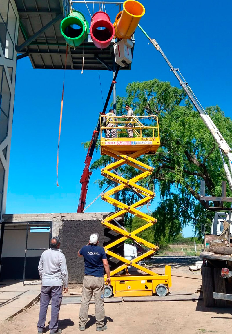 Plataforma de tijera elevando operarios en instalación exterior