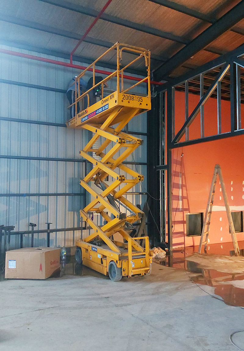 Plataforma de tijera compacta trabajando en interior
