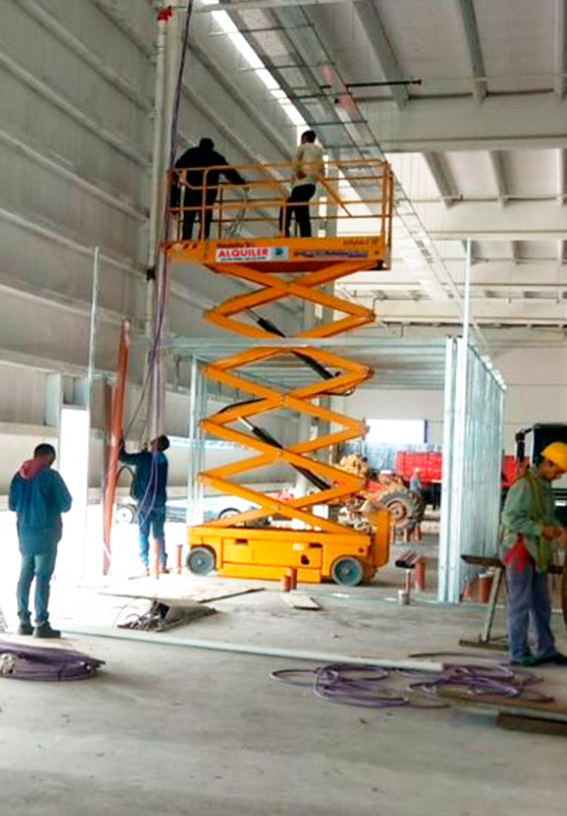 Plataforma de tijera amarilla instalada en obra interior